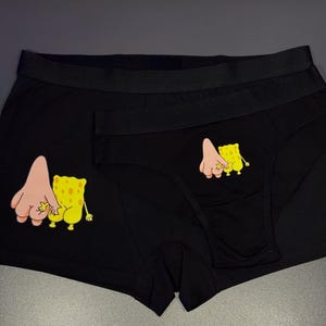 Puede incluir: Conjunto de ropa interior negra con un dibujo animado de Bob Esponja y Patricio Estrella. El conjunto incluye un bóxer y una braguita. El dibujo muestra a los personajes tomados de la mano. La ropa interior es de material suave.