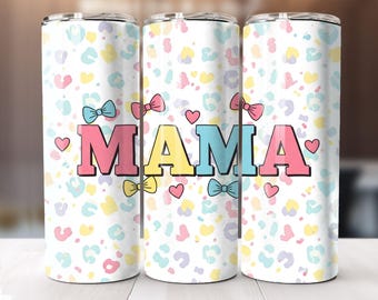 May include: Three stainless steel tumblers with a white background and a colorful leopard print pattern. The tumblers have the word "MAMA" written in large, colorful letters with bows on either side of the word.
