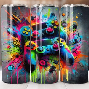 May include: A colorful, abstract design featuring two video game controllers with bright splashes of paint. The design is perfect for a tumbler or other drinkware.