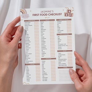 Puede incluir: Una lista de verificación de los primeros alimentos para bebés titulada "Jasmine's First Food Checklist" con un arcoíris y un gráfico de bloques ABC. La lista incluye categorías para verduras, frutas, hierbas, especias, alérgenos principales, lácteos, cereales, proteínas y otros alimentos.