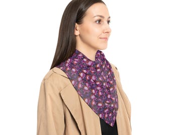 May include: A woman wearing a tan trench coat with a purple and pink floral patterned scarf.