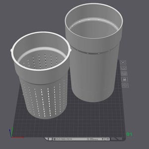 May include: Two grey cylindrical containers. One has a perforated body and a wider rim, while the other is a solid cylinder with a narrower rim. Both are on a grey surface with a grid pattern.