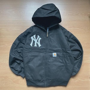 Può includere: Giacca con cappuccio nera con logo bianco dei New York Yankees sul petto. La giacca ha una zip intera, una piccola toppa con logo Carhartt e una vestibilità rilassata. Realizzata in materiale resistente alle intemperie.