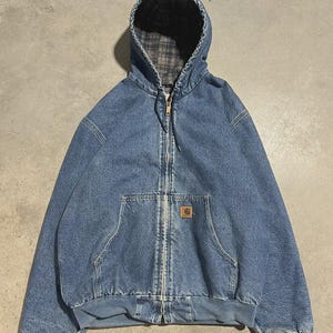 Puede incluir: Chaqueta con capucha de mezclilla azul con cremallera completa y parche con el logotipo marrón. El forro de la capucha presenta un estampado de cuadros. La chaqueta tiene dos bolsillos delanteros y puños y dobladillo acanalados.
