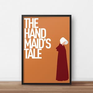 May include: Framed poster with the words "THE HANDMAID'S TALE" in white. It shows a minimalist illustration of a figure in a red cloak and white bonnet on an orange background. The poster is in a black frame.