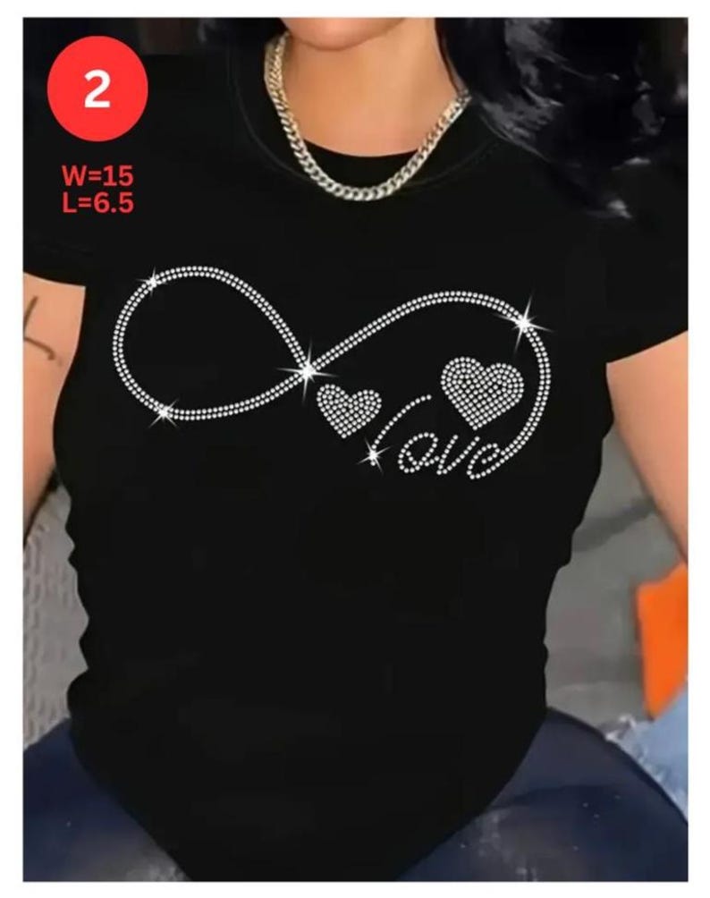 May include: Black short-sleeved t-shirt with a rhinestone infinity symbol design, two rhinestone hearts, and the word "love". The shirt has the measurements W=15 and L=6.5 in red text in the upper left corner.