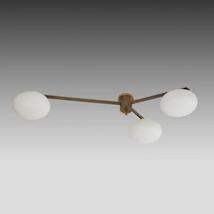 Può includere: Un moderno lampadario a soffitto con tre paralumi a globo bianchi. L'apparecchio ha una finitura bronzo e un design minimalista, ideale per interni contemporanei. La luce è sospesa al soffitto.