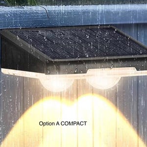 May include: A black solar-powered outdoor wall light with a rectangular solar panel on top and two rounded light diffusers emitting a warm glow. The unit is mounted on a vertical surface during rain and features the text Option A COMPACT.