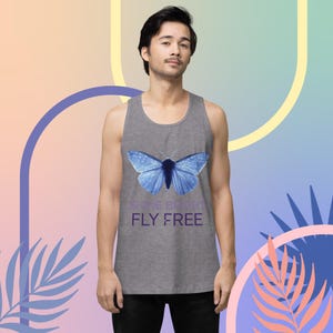 Könnte beinhalten: Ein graues Tanktop mit einem blauen Schmetterlingsmotiv und dem Text "Shine Bright, Fly Free".