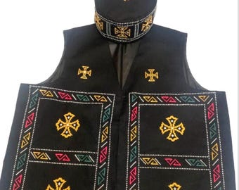 Puede incluir: Chaleco negro y gorro a juego con cruces doradas bordadas y patrones geométricos. El chaleco presenta un diseño sin mangas con paneles decorativos y un borde detallado en rojo, verde y blanco. El gorro tiene una corona redonda y una banda estampada.