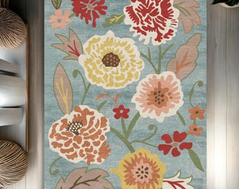 May include: A blue rug with a floral pattern. The rug features large, colorful flowers in shades of red, yellow, orange, and pink. The flowers are surrounded by green leaves and stems.