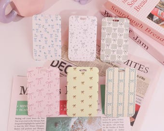 May include: Six different patterned luggage tags with a hole for a strap. The tags are all rectangular and feature a variety of pastel colors and patterns, including bows, stripes, and polka dots.
