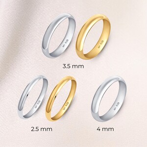 May include: Five rings in silver and gold, with sizes 2.5 mm, 3.5 mm, and 4 mm. Each ring is marked with "am 925". The rings are displayed on a light pink background. The ring sizes are approximately 0.10, 0.14, and 0.16 inches.