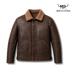 Peut inclure: Une veste en cuir marron foncé avec un col en peau lainée beige, une fermeture à boutons sur le devant et deux poches avant. Le logo dans le coin supérieur droit affiche le texte MIL EST. 1999 MADE IN LEATHERS avec une icône de bois.