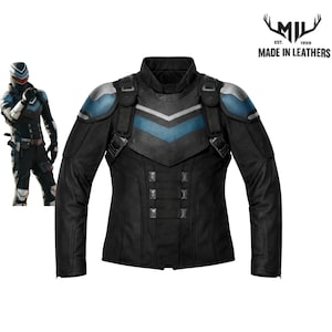 Peut inclure: Veste en cuir noire avec des détails bleus et argentés. La veste présente un col montant, des épaulettes et un motif en chevrons sur la poitrine. Elle comporte plusieurs boucles et le texte "MADE IN LEATHERS" est visible.