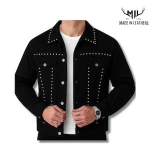 May include: A black jacket featuring silver-toned metal studs along the collar, chest, and front panels. The garment includes two chest pockets with button closures and a central button-down placket. The logo MIL EST. 1999 MADE IN LEATHERS is visible.