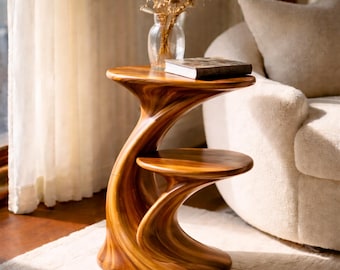 Tavolino laterale scultoreo a forma di onda in legno massello con ripiano, complemento d'arredo moderno e organico.