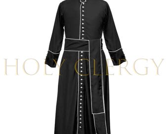 May include: A black clergy robe with white trim and buttons. The long-sleeved robe features a high collar and a matching sash. The text "HOLY CLERGY" is visible in the lower left corner of the image.