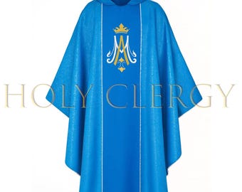 May include: A blue liturgical vestment with a hood and a central panel. The vestment features a gold crown and a stylized "M" emblem. White vertical stripes run down the front. The text "HOLY CLERGY" is printed across the bottom.