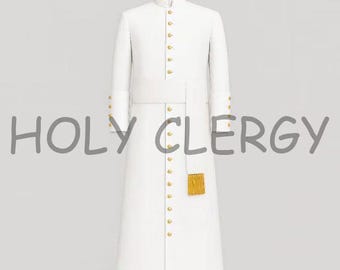Può includere: Una veste bianca da clero con bottoni e finiture dorate, esposta su un manichino di legno. La veste presenta un colletto alto, maniche lunghe e una gonna lunga. Il testo "HOLY CLERGY" è visibile.
