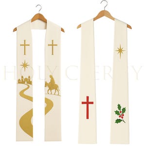 May include: Off-white clergy stoles with religious symbols. One stole features gold crosses, a star, a path, and a figure on a donkey. The other has a red cross, a star, and holly with red berries. Both are hanging on wooden hangers.