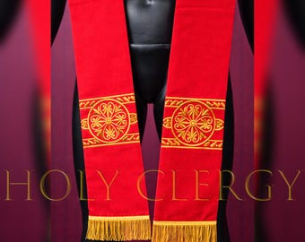 Puede incluir: Estola litúrgica roja con diseño floral bordado en oro y flecos dorados. El texto "HOLY CLERGY" se muestra en oro. La estola está hecha de tela roja.
