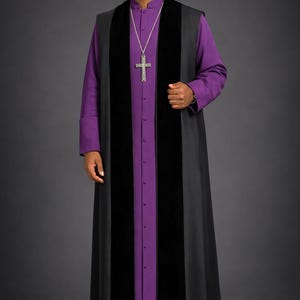 Puede incluir: Una túnica formal de clérigo con un chaleco negro largo con dos paneles de terciopelo negro sobre una camisa morada abotonada. Un colgante de cruz plateada cuelga de una cadena. La túnica es usada por una persona.