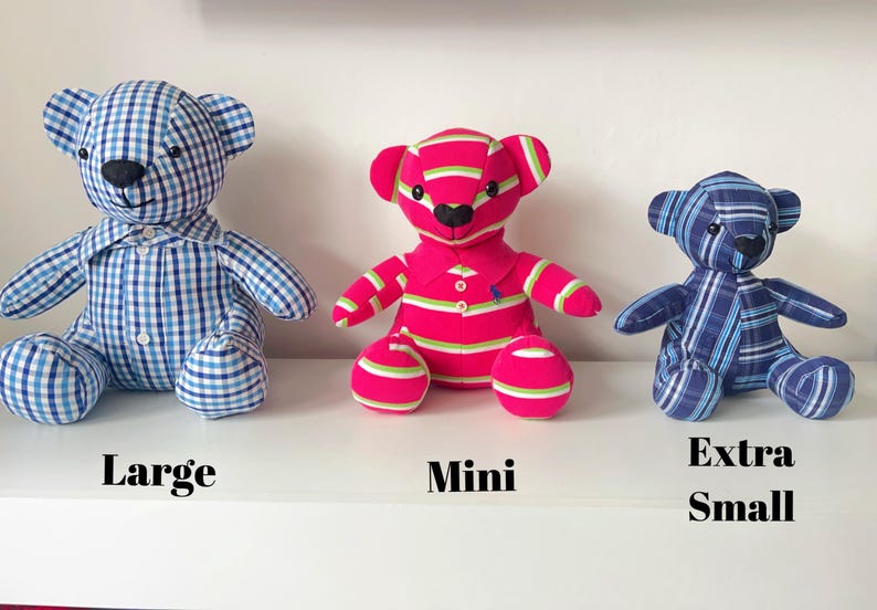 May include: Three stuffed teddy bears in different sizes. The large bear is blue and white checkered. The mini bear is pink with green and white stripes. The extra small bear is blue and white striped. Text on the shelf reads "Large", "Mini", and "Extra Small".