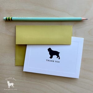 Puede incluir: Un juego de papelería con una tarjeta blanca con una silueta de perro negro y las palabras "THANK YOU". El juego incluye un sobre amarillo-verdoso y un lápiz verde claro. El logotipo de Oliver Blu está en la esquina inferior izquierda.