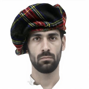 Puede incluir: Boina escocesa negra, roja y verde. La boina presenta un patrón de tartán clásico con rayas amarillas y blancas. Esta boina suave tiene forma redonda y es un estilo clásico de sombrerería.