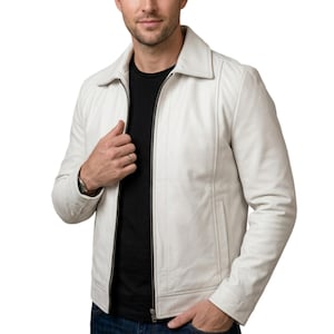 May include: Cream-colored leather jacket with a zip-up front, a collar, and two side pockets. The jacket is worn over a black t-shirt. The model is wearing blue jeans.
