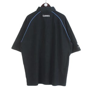 May include: Black short-sleeved polo shirt with blue trim and the word "GUINNESS" embroidered on the back.