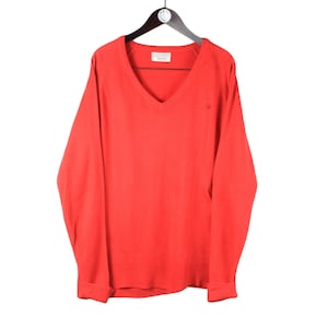 Può includere: Un maglione rosso a collo a V a maniche lunghe con un piccolo logo sul petto.