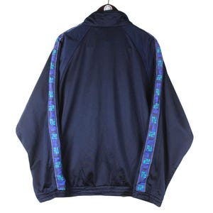 Puede incluir: Una chaqueta de ch&aacute;ndal azul marino con cierre de cremallera y ribetes blancos. La chaqueta tiene ribetes azules y morados con texto repetido a lo largo de las mangas y los lados.