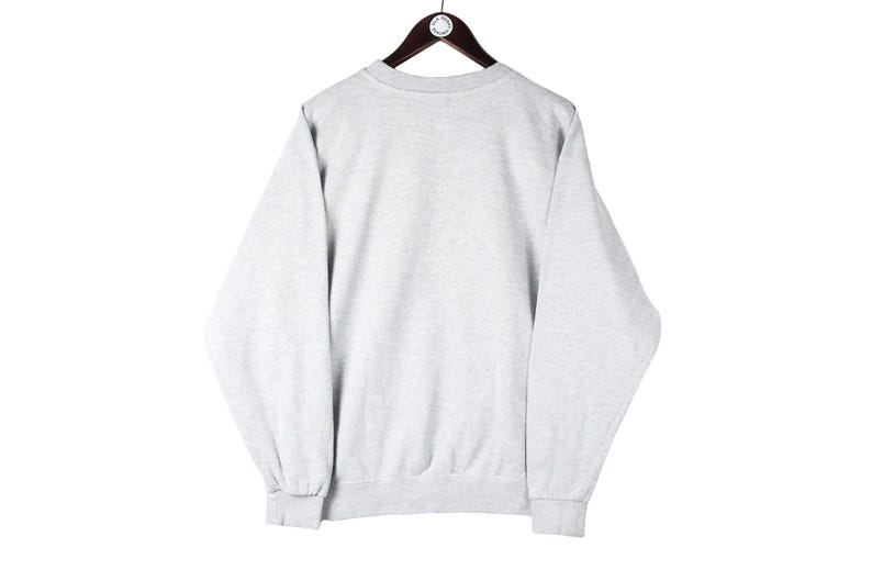 Puede incluir: Una sudadera gris con mangas largas y cuello redondo.