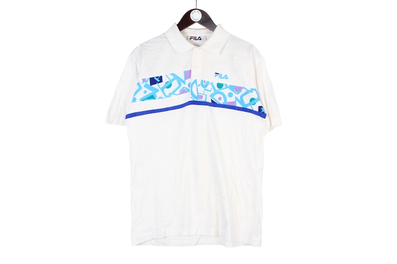 May include: A white ceramic mug with a black handle and the text "But First, Coffee" in a handwritten style. The mug is on a white surface. The mug is approximately 4 inches tall.