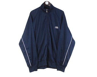 May include: Navy blue zip-up track jacket with white piping along the sleeves. The jacket has a stand-up collar and a small white logo on the chest. The jacket is made of a lightweight material.