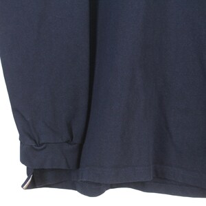 May include: Navy blue long-sleeve shirt. The shirt has a crew neck and a ribbed cuff. The bottom hem is straight. The fabric appears to be a soft, knit material. The shirt is a solid color.