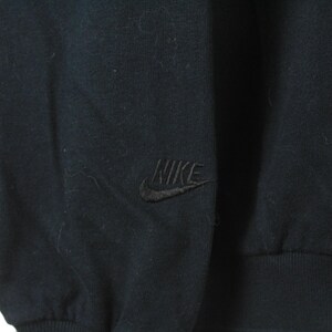 Może przedstawiać: Czarna bluza z długim rękawem z haftowanym logo Nike na lewej piersi.