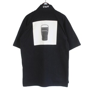 May include: Black short-sleeved shirt with a white square on the back featuring a Guinness pint glass graphic. The word "STAFF" is embroidered on the collar.