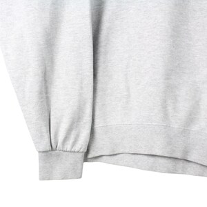 Puede incluir: Una sudadera gris con mangas largas y dobladillo de canal&eacute;.