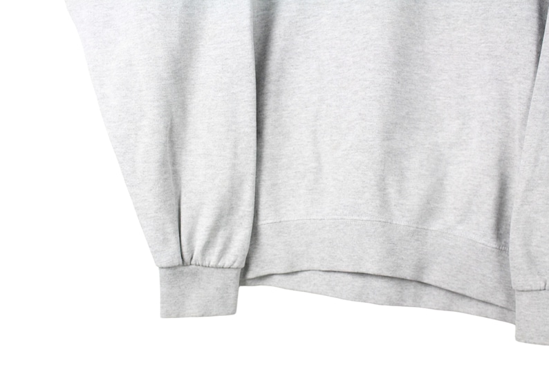 Puede incluir: Una sudadera gris con mangas largas y dobladillo de canal&eacute;.