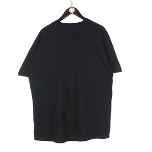 Op de afbeelding: Een zwart T-shirt met korte mouwen hangt aan een houten hanger. Het shirt is effen en lijkt van een zacht materiaal te zijn. De achtergrond is wit.