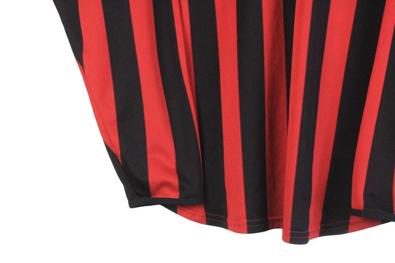 Puede incluir: Primer plano de una tela a rayas rojas y negras. Las rayas verticales se alternan en color, creando un patr&oacute;n audaz. La tela parece ser un material ligero, posiblemente para ropa.