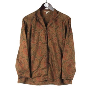 Puede incluir: Una camisa de manga larga con botones y un estampado paisley en tonos marrones, naranjas y verdes.