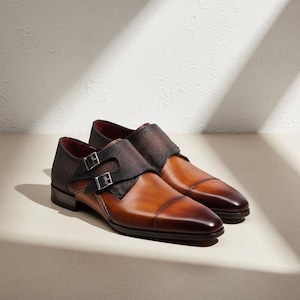 Sapatos sociais masculinos de couro marrom feitos à mão com fivela dupla.