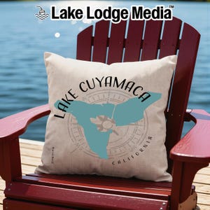 May include: A square off-white throw pillow featuring a teal map silhouette of Lake Cuyamaca, California. The design includes a compass rose graphic behind the map and black text reading Lake Cuyamaca California in a circular arrangement.