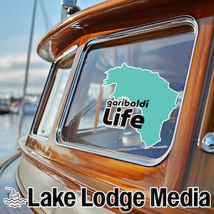 May include: A teal-colored sticker applied to a boat window, featuring a map outline and the black text "garibaldi Life". The sticker includes a small copyright notice "© Lake Lodge Media LLC" at the bottom of the graphic design.
