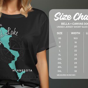 May include: Black unisex short sleeve tee featuring a teal map of Lizard Lake in Minnesota. The shirt includes the text "Beautiful Lizard Lake Minnesota" and a size chart with measurements in inches.