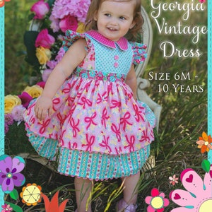 May include: A little girl wearing a pink and blue dress with a bow in her hair. The dress has a pink and white bow print and a blue and white polka dot print. The dress is called "Georgia Vintage Dress" and is available in sizes 6 months to 10 years. The image is surrounded by colorful flowers.